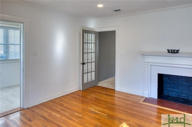 unfurnished living room featuring wood-type flooring and ornamental molding