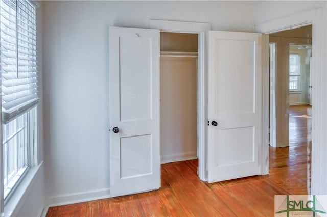 unfurnished bedroom with light hardwood / wood-style flooring and a closet