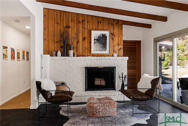 sitting room featuring a fireplace and beamed ceiling