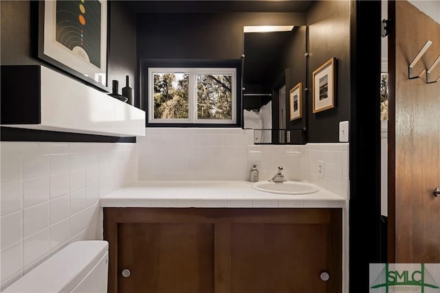 bathroom with vanity, tasteful backsplash, and toilet