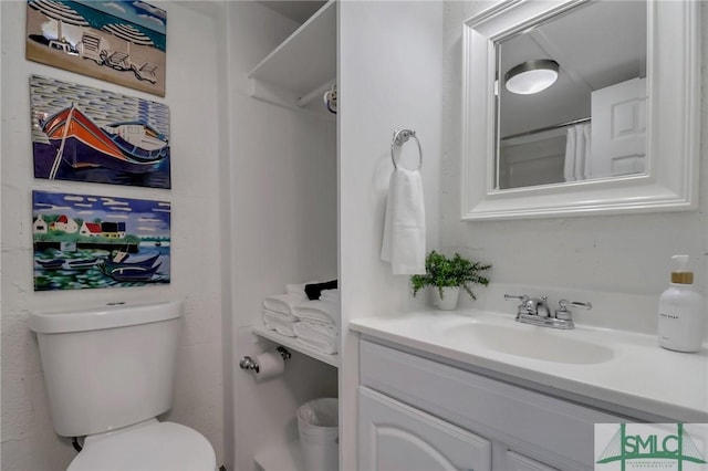 bathroom featuring vanity, toilet, and curtained shower