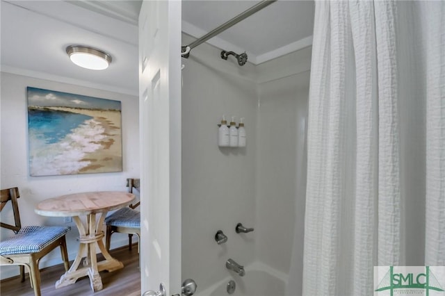 bathroom with hardwood / wood-style flooring, ornamental molding, and shower / tub combo