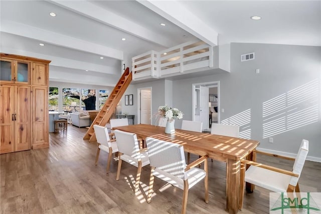 dining room featuring beam ceiling and light wood-type flooring