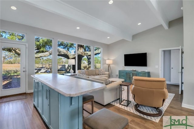 living room with beamed ceiling and wood-type flooring