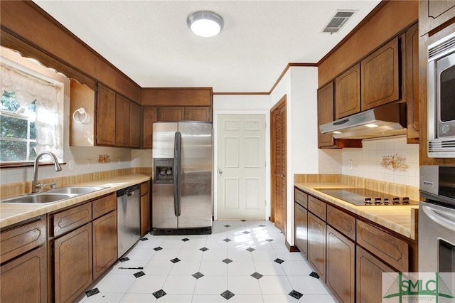 kitchen featuring backsplash, crown molding, sink, and appliances with stainless steel finishes