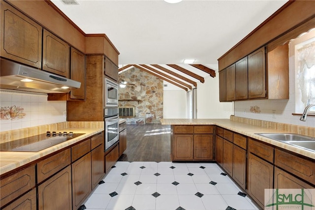 kitchen featuring sink, stainless steel appliances, vaulted ceiling with beams, backsplash, and kitchen peninsula