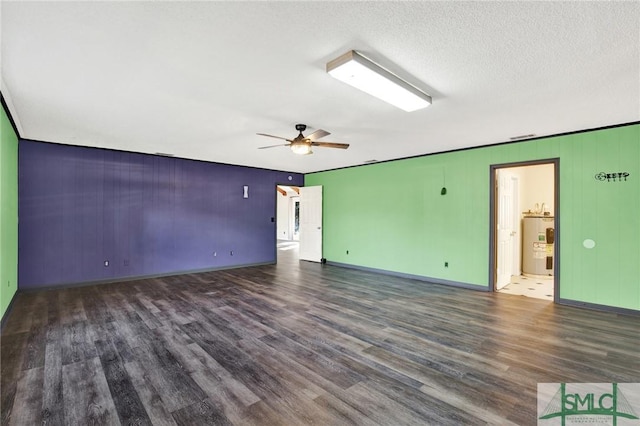 unfurnished room with dark hardwood / wood-style floors, ceiling fan, a textured ceiling, and water heater