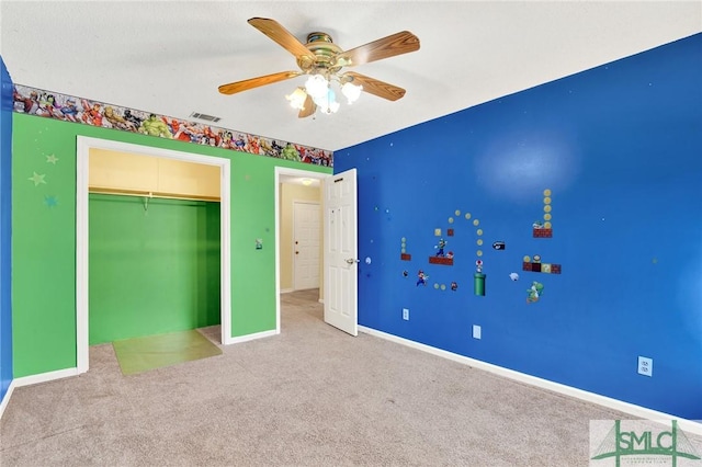 unfurnished bedroom featuring ceiling fan, light colored carpet, and a closet