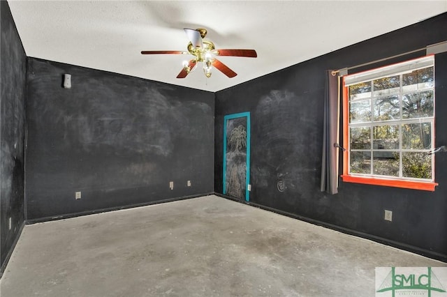 spare room with concrete floors and ceiling fan