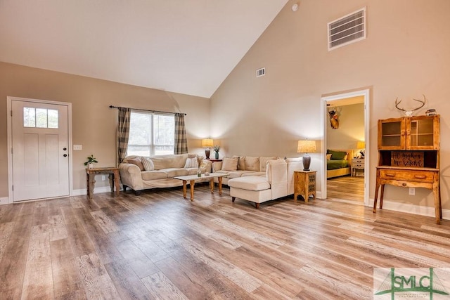 living room featuring hardwood / wood-style flooring, high vaulted ceiling, and a wealth of natural light