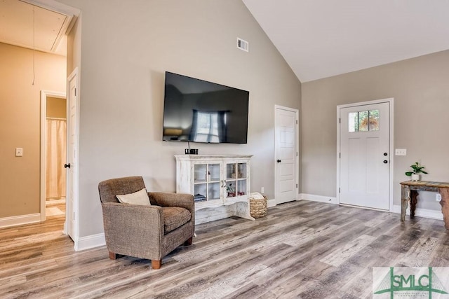 living room featuring hardwood / wood-style flooring and high vaulted ceiling