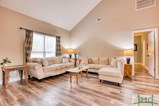 living room with high vaulted ceiling and wood-type flooring