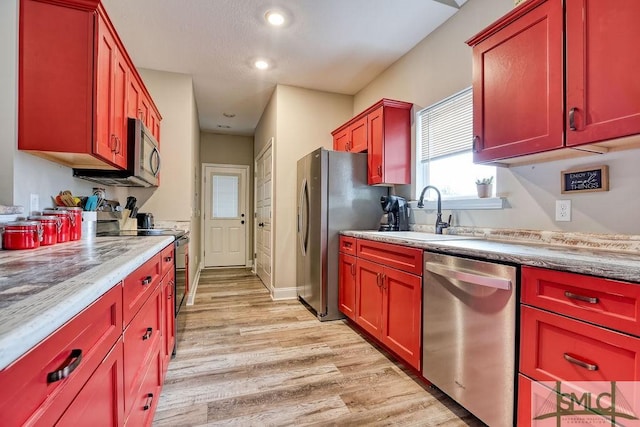 kitchen featuring stainless steel appliances, light hardwood / wood-style floors, and sink