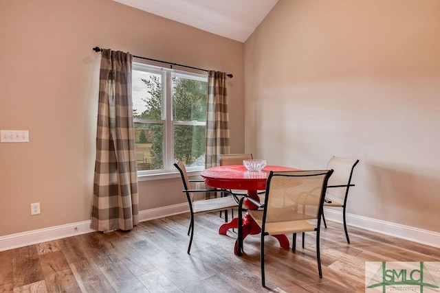 dining area featuring lofted ceiling, hardwood / wood-style floors, and plenty of natural light