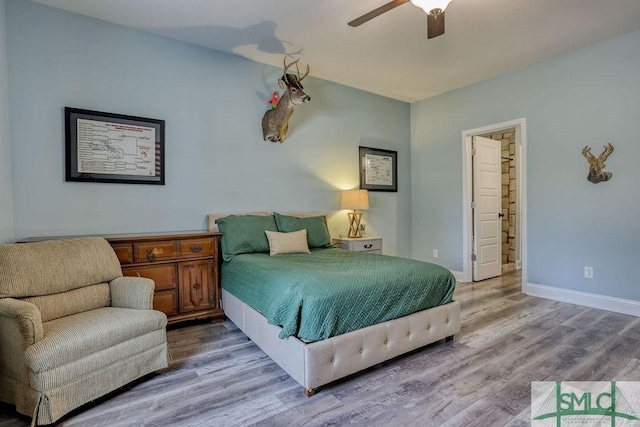 bedroom featuring hardwood / wood-style floors, ceiling fan, and ensuite bath