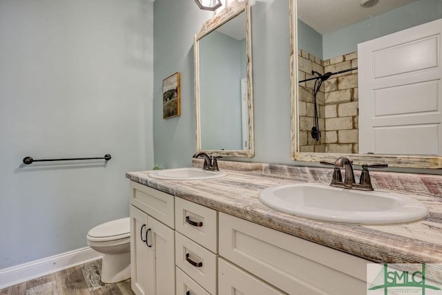 bathroom featuring toilet, a tile shower, vanity, and hardwood / wood-style flooring