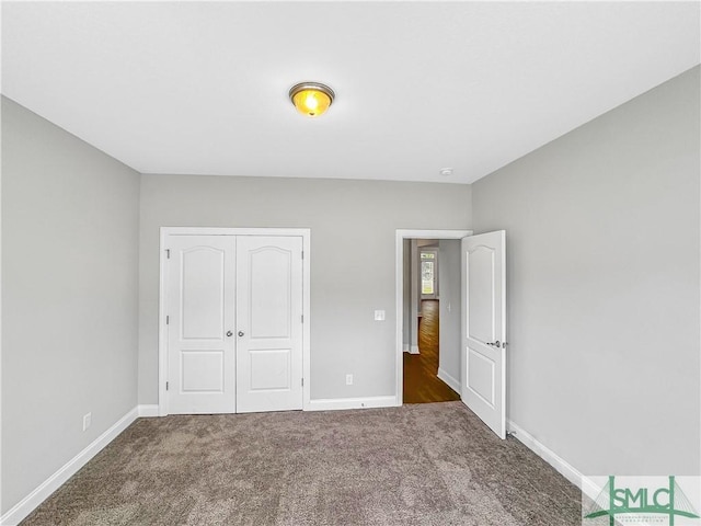 unfurnished bedroom featuring dark colored carpet and a closet