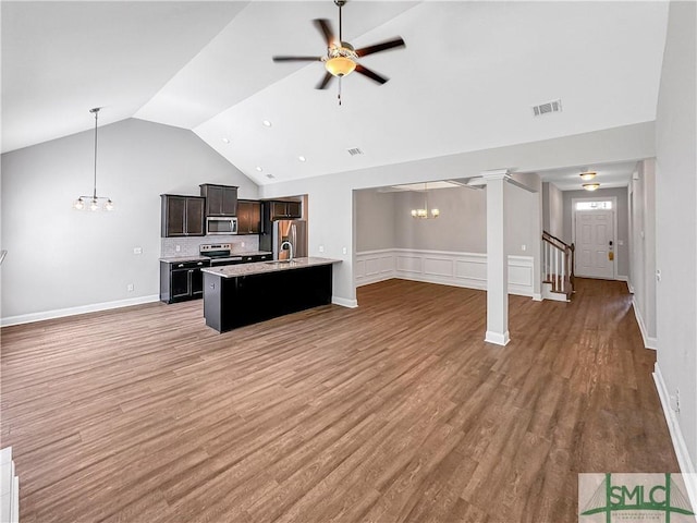 living room featuring lofted ceiling, hardwood / wood-style floors, and ceiling fan with notable chandelier