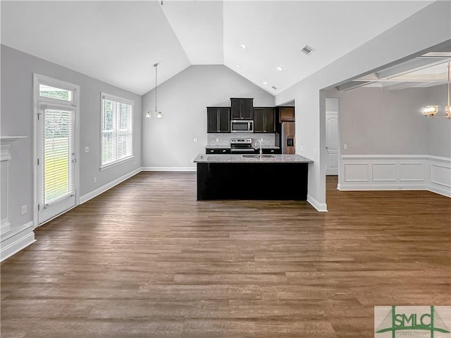 kitchen with a center island with sink, sink, hanging light fixtures, appliances with stainless steel finishes, and dark hardwood / wood-style flooring