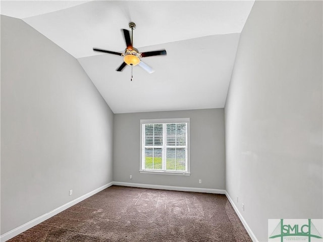 carpeted spare room with ceiling fan and vaulted ceiling