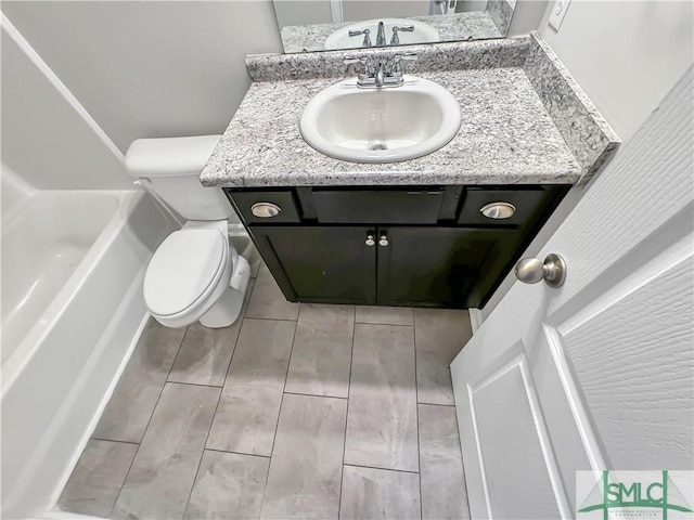 bathroom with a bath, vanity, and toilet