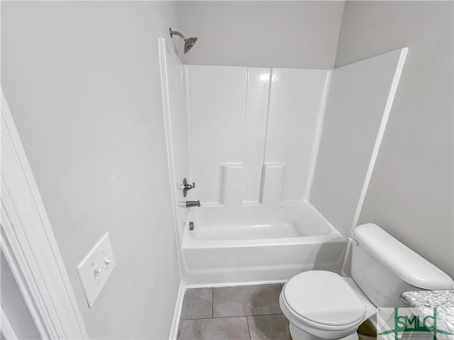 bathroom featuring tile patterned flooring, toilet, and washtub / shower combination