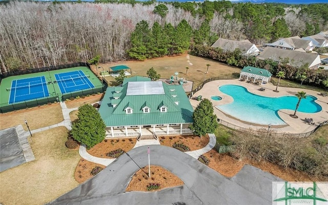 bird's eye view of a pool and a heavily wooded area