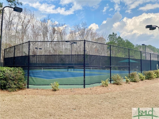 view of tennis court featuring fence