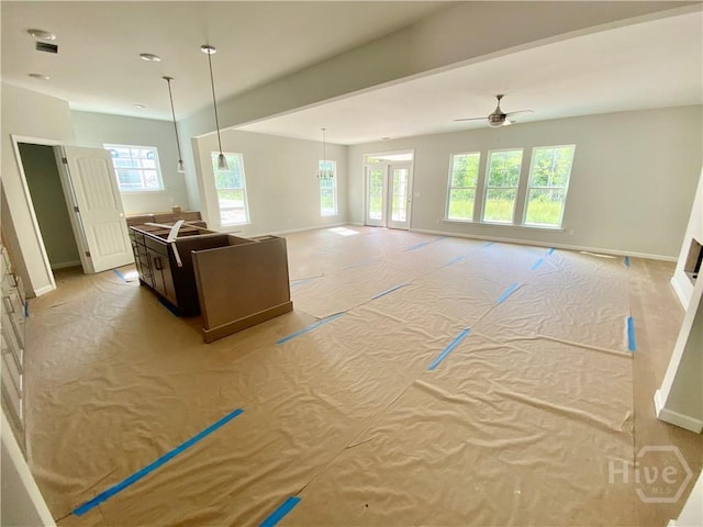 living room with ceiling fan and baseboards