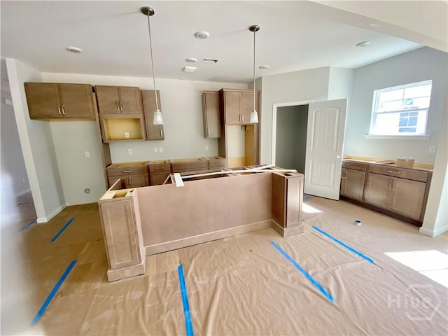 kitchen featuring hanging light fixtures, baseboards, and a center island