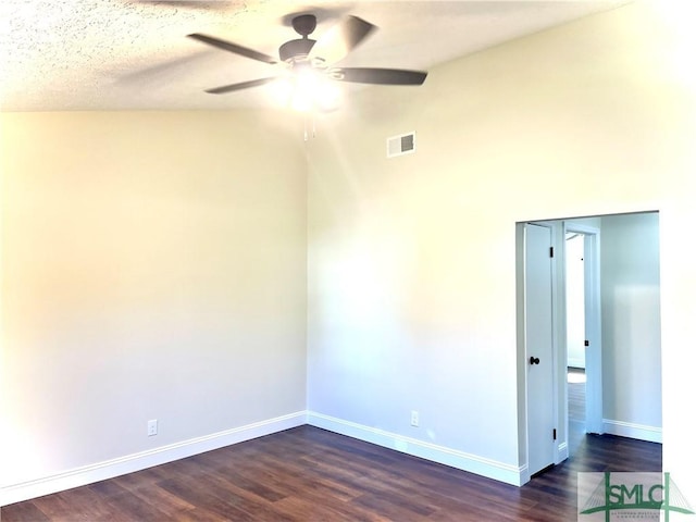 spare room with vaulted ceiling, ceiling fan, dark wood-type flooring, and a textured ceiling