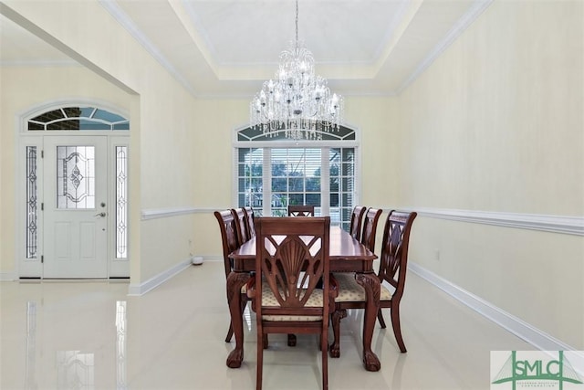 dining room featuring an inviting chandelier, ornamental molding, and a tray ceiling