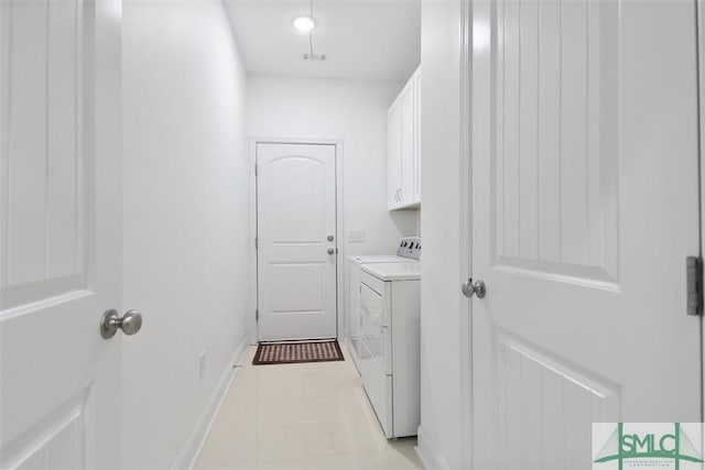 washroom with washing machine and clothes dryer and cabinets