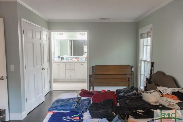 bedroom featuring connected bathroom and ornamental molding