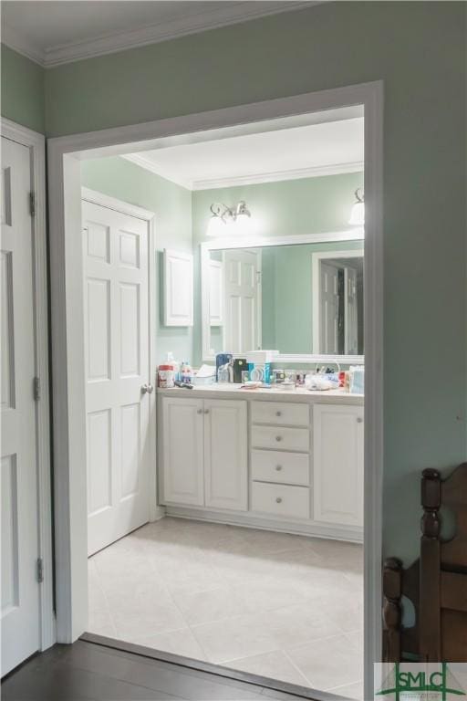 bathroom featuring tile patterned floors, crown molding, and vanity