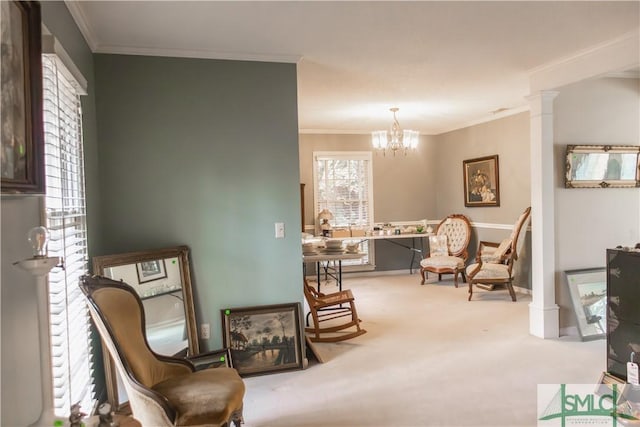 living area featuring a notable chandelier, carpet floors, ornamental molding, and decorative columns