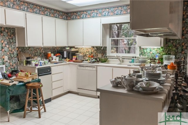 kitchen with backsplash, dishwasher, white cabinets, and sink