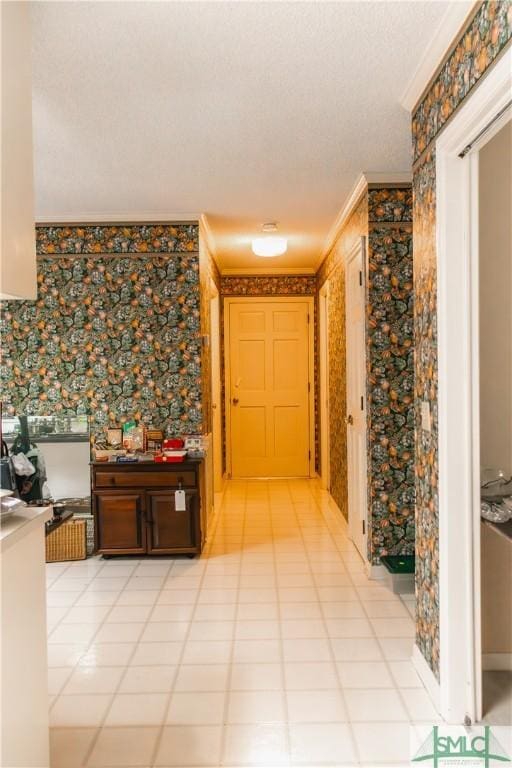 hallway with light tile patterned floors and crown molding