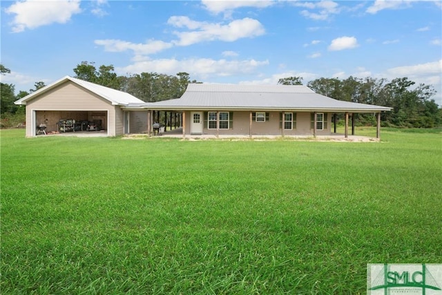 back of house with covered porch, a garage, and a lawn