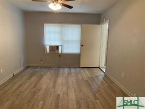 empty room featuring ceiling fan, light hardwood / wood-style floors, and cooling unit