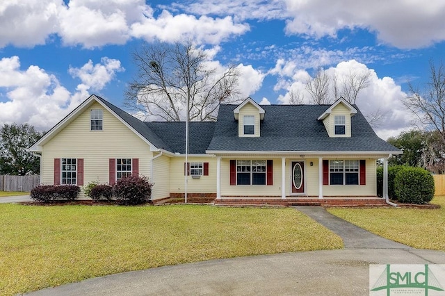 cape cod home with covered porch and a front lawn