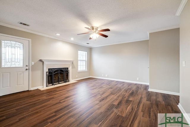 unfurnished living room featuring ceiling fan, dark wood-type flooring, a textured ceiling, and ornamental molding