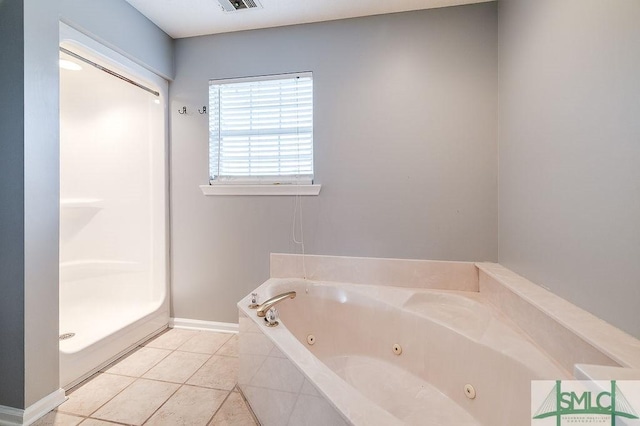 bathroom with tile patterned flooring and tiled bath