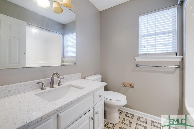 bathroom featuring plenty of natural light, toilet, and vanity