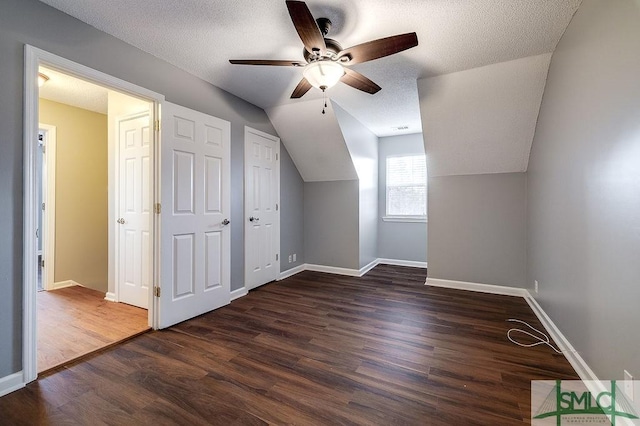 additional living space featuring dark hardwood / wood-style floors, ceiling fan, a textured ceiling, and vaulted ceiling