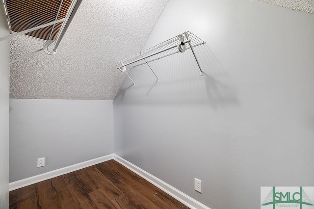 walk in closet with wood-type flooring and vaulted ceiling