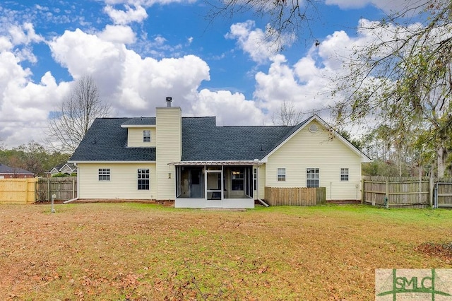 back of property featuring a sunroom and a yard