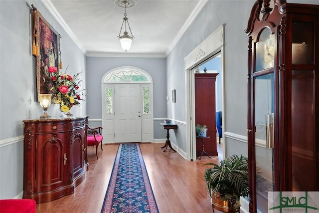 foyer with light hardwood / wood-style floors and crown molding