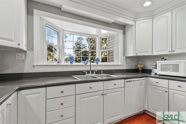 kitchen with white appliances, sink, hardwood / wood-style flooring, and white cabinetry