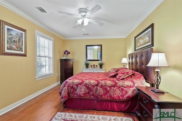 bedroom featuring ornamental molding, a textured ceiling, ceiling fan, and light hardwood / wood-style floors